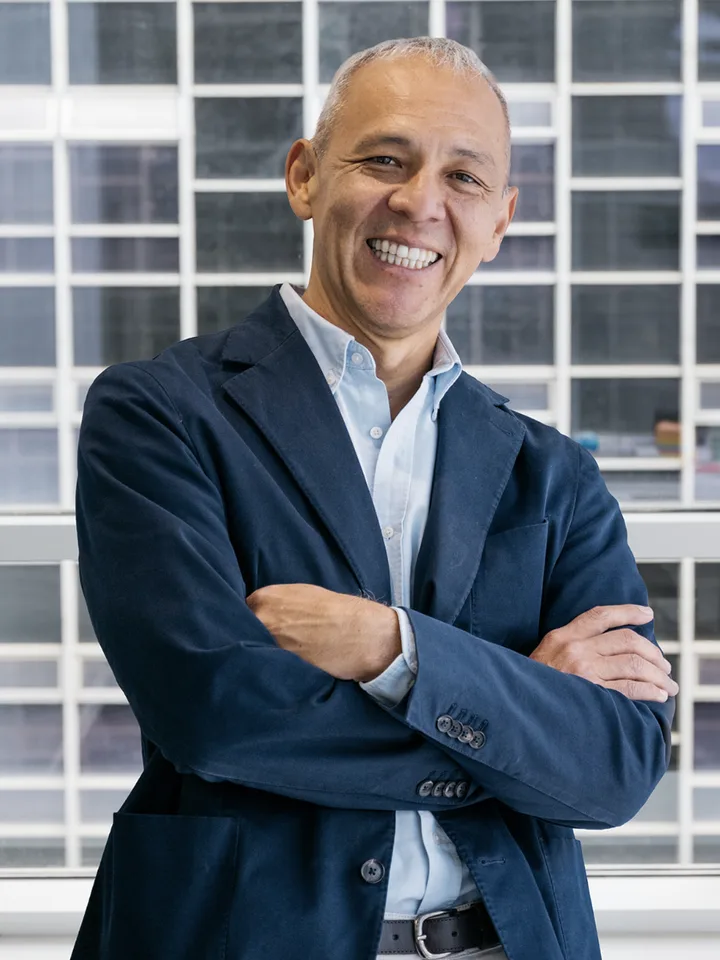 Alfredo Leonardo, de HeliOx, sonriendo con los brazos cruzados delante de un ventanal