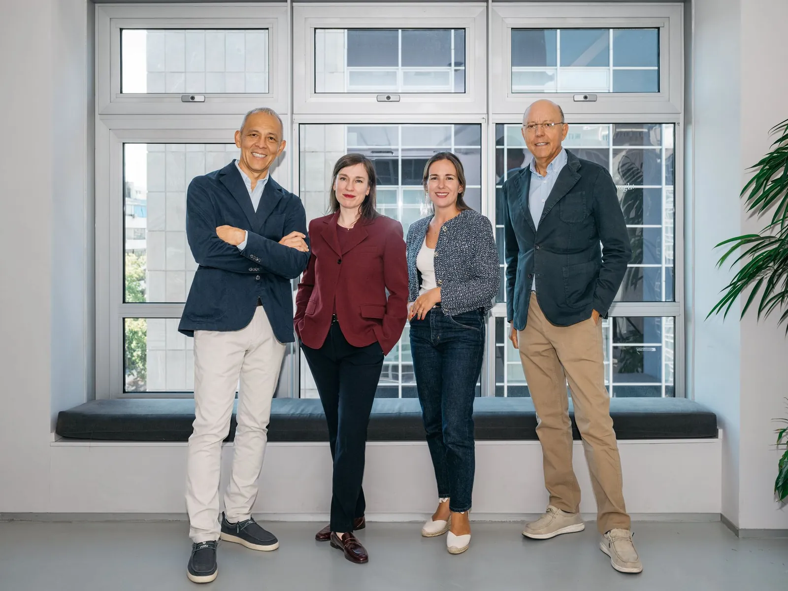 Las cuatro personas del equipo de HeliOx, de pie y sonrientes, delante de un gran ventanal